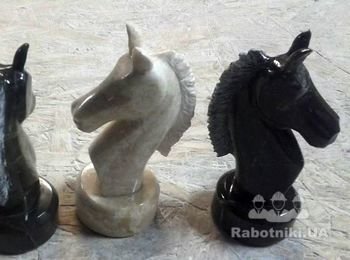 Шахматная фигурв - конь из мрамора, бежевого и черного камня