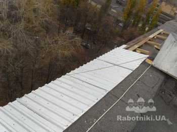 Покрываем участок крыши профнастилом оцинкованным с уклоном наружу. Фото сделано с крыши дома непосредственно в процессе монтажа.